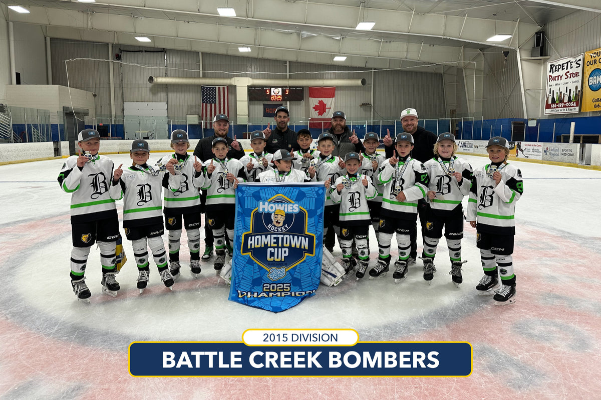 Hockey team posing with a trophy on an ice rink, with 'Battle Creek Bombers' displayed.