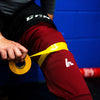 Yellow shin pad tape on maroon socks 