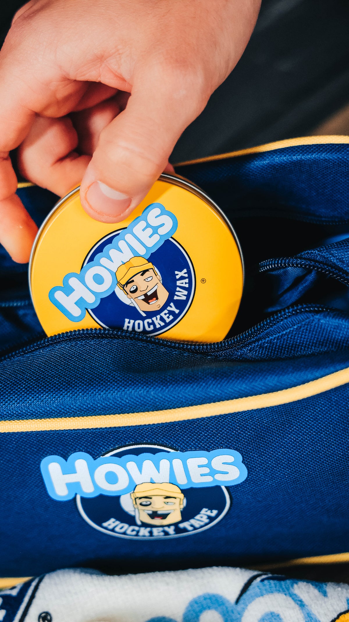 Hand pulling a tin of Howies Hockey Wax out of an accessory bag