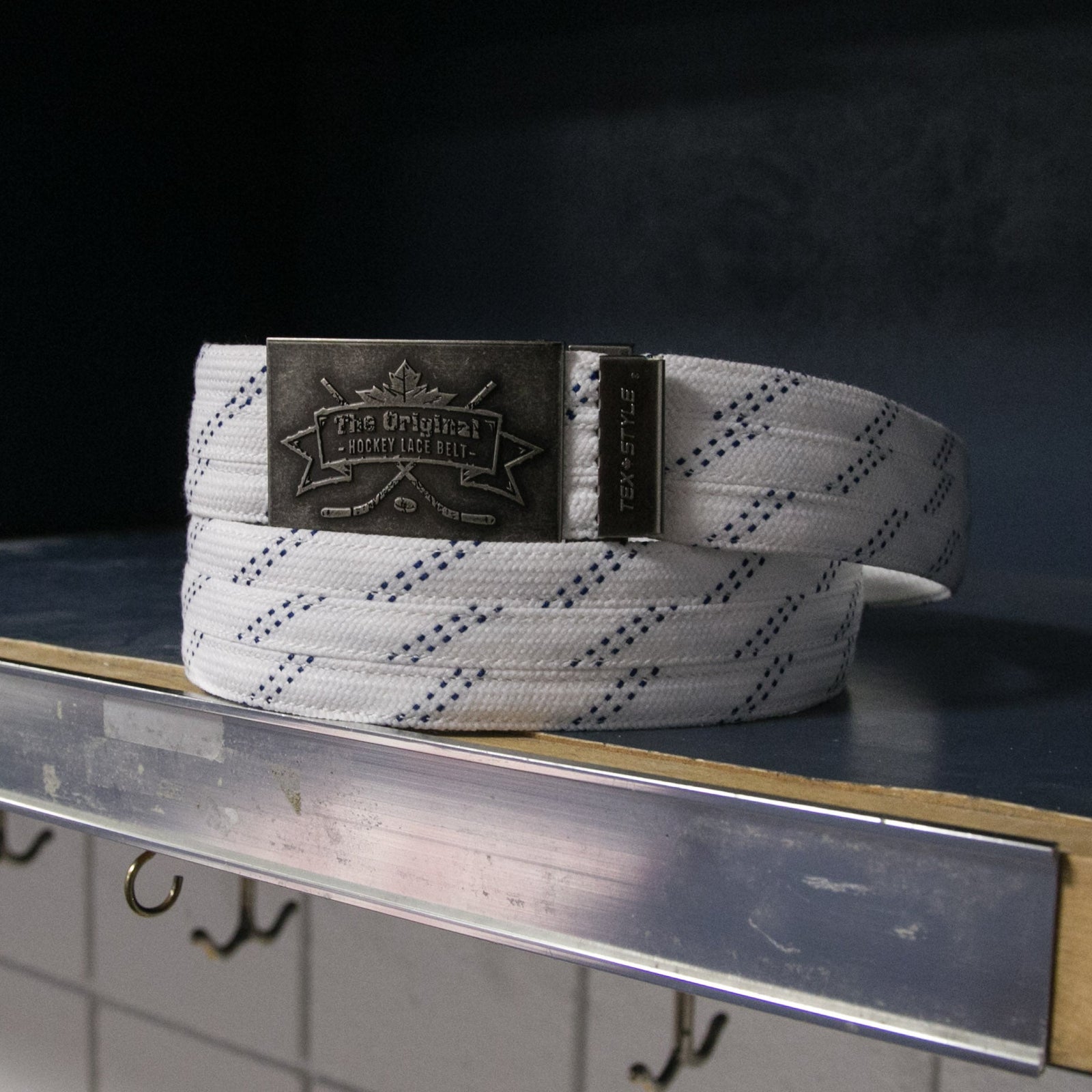 White belt with a metallic buckle on a metal surface