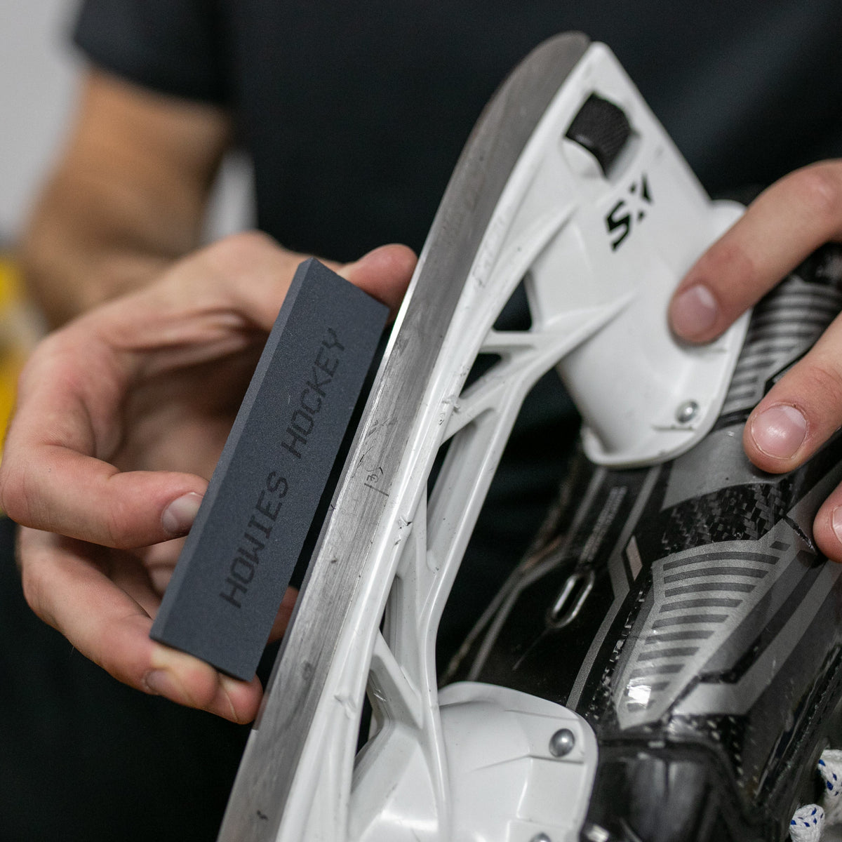 Howies fine honing stone being used on a hockey skate blade