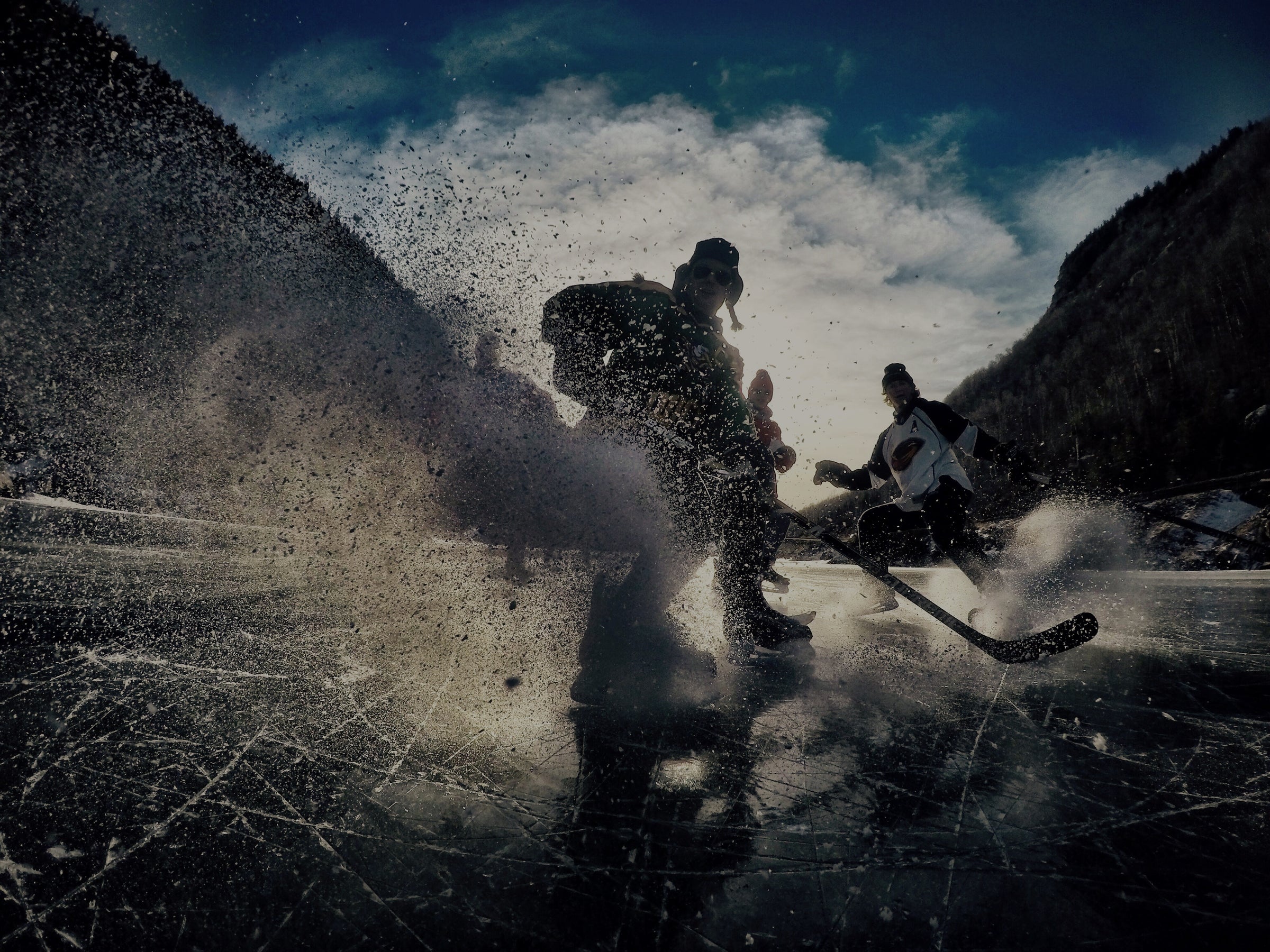 people playing hockey on a frozen pond