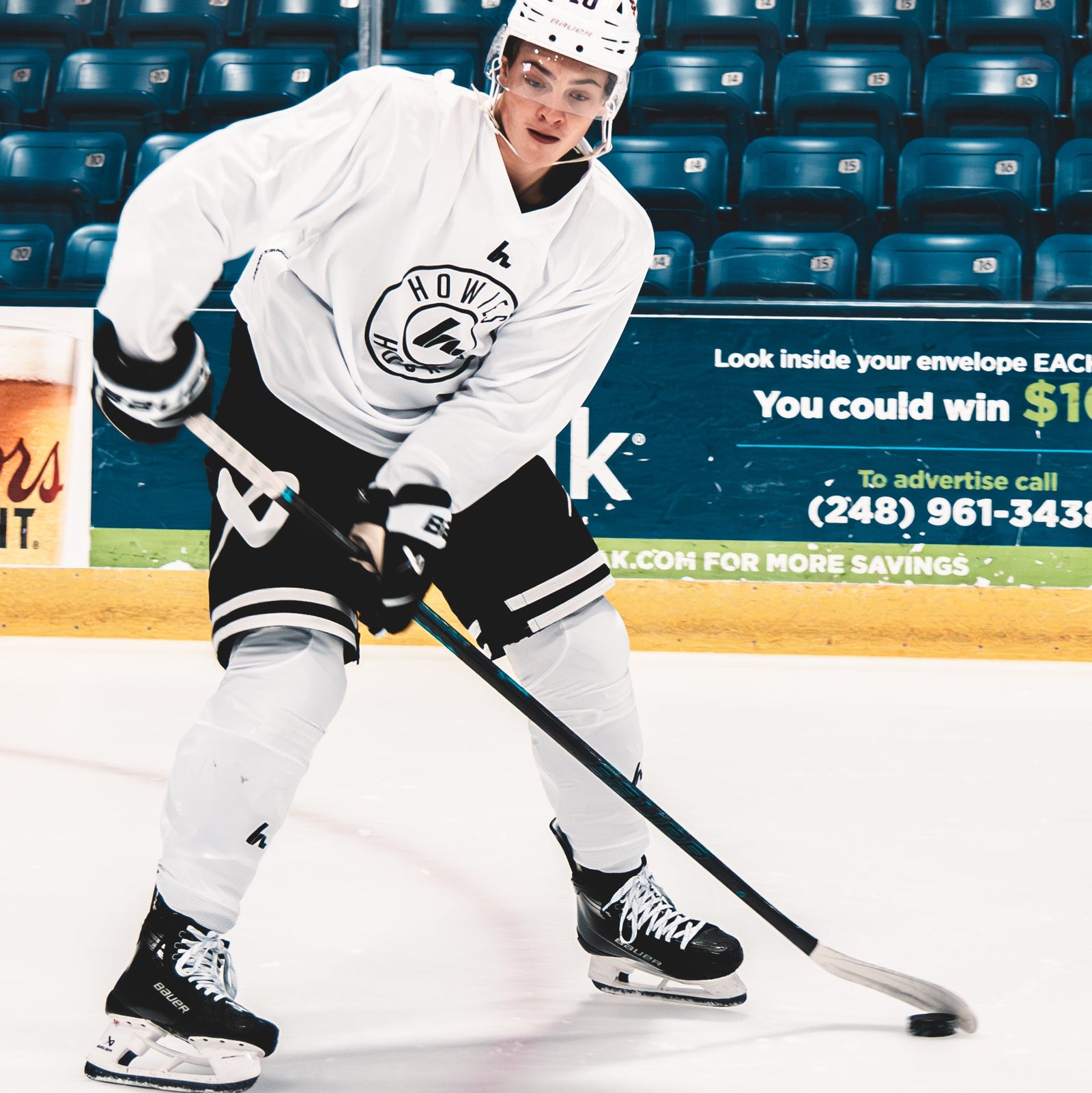 Hockey player in action on an ice rink with advertisements in the background