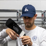 guy taping his stick in a navy blue hat 