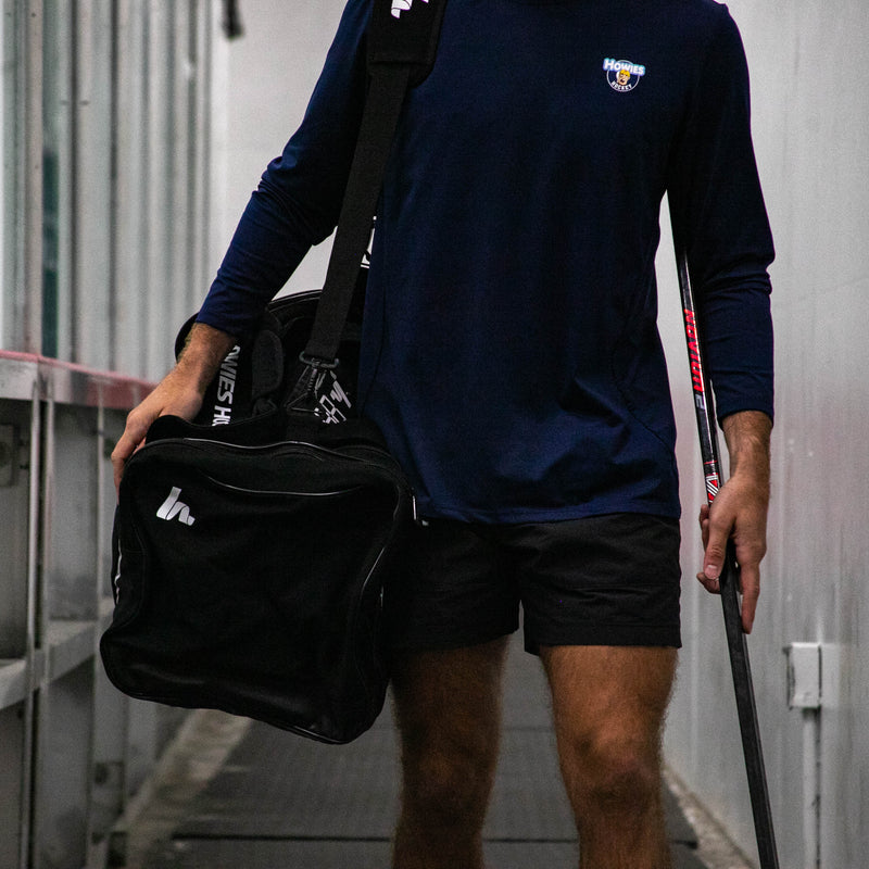 Person holding a black bag and walking in an industrial setting