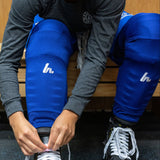 Person adjusting ice skates in a locker room setting