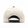 Rear view of the Clean Sheet Lid in cream with a black adjustable snapback closure and Howies tag