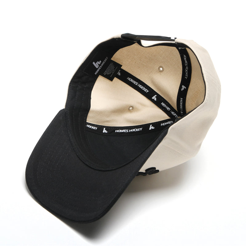 Underside view of the Clean Sheet Lid showing the black brim, cream interior and custom Howies Hockey branded taping inside the hat