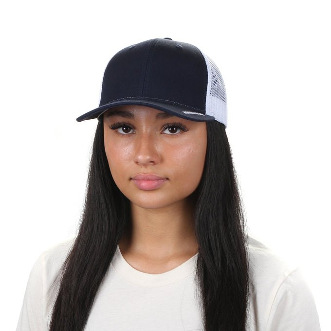Person wearing a navy blue cap with white mesh back on a white background